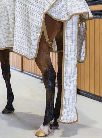 Horse wearing a checkered Eurohunter horse rug in a stable.