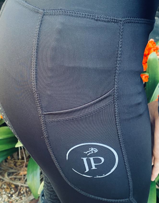 Close-up of black Horse Riding Tights with a logo on thigh.