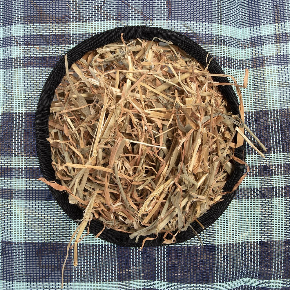 Circular hay feeder filled with straw on a checkered blue background.