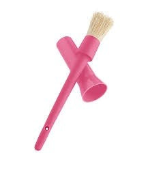 A pink silicone basting brush with its head resting in a coordinating holder, isolated on a white background.