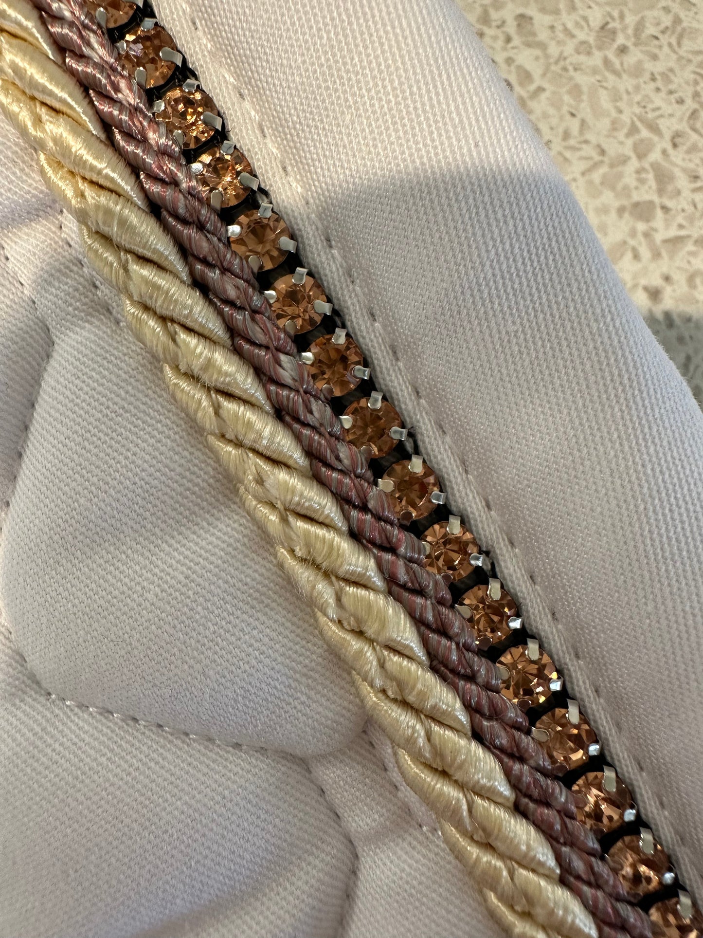 Alt: Close-up of Anna Scarpati fabric with gold sequins and braided trim.