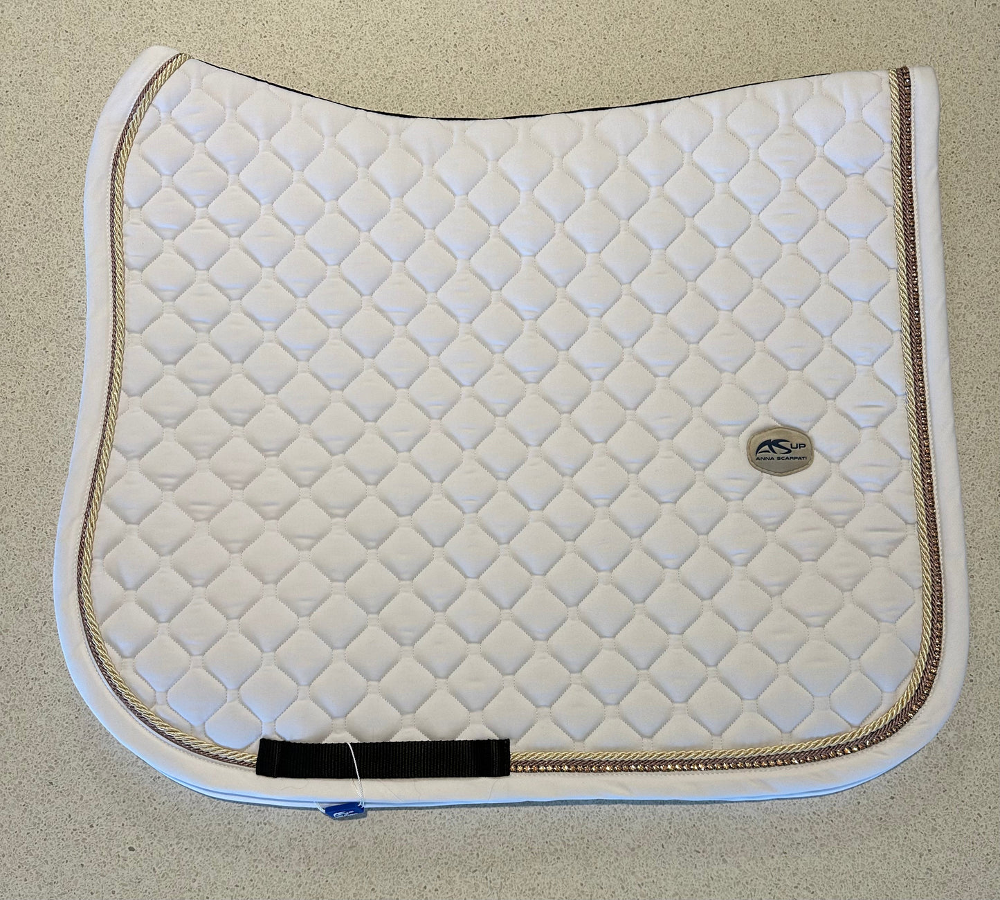 Anna Scarpati white quilted horse saddle pad with gold trim.