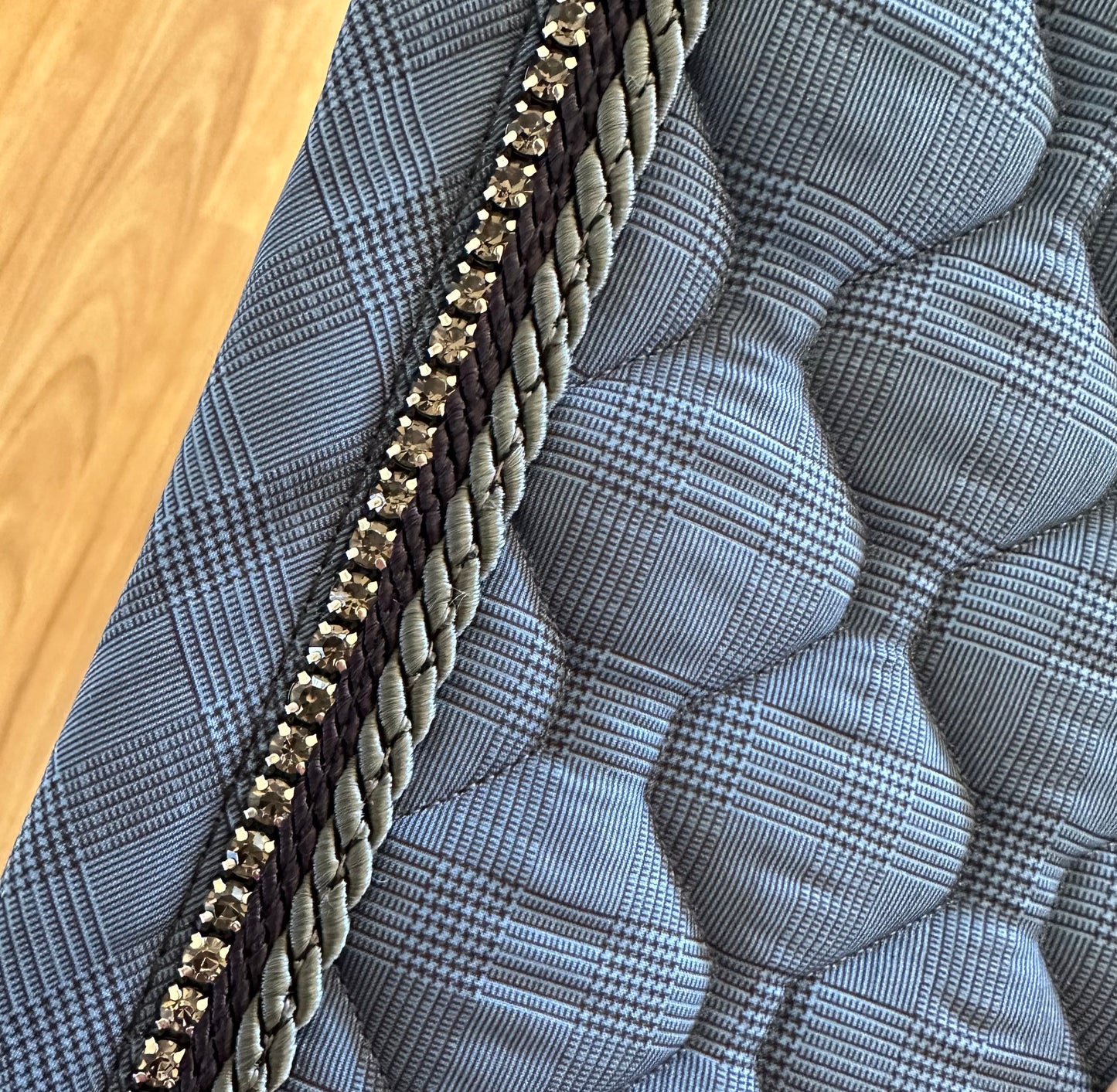 Anna Scarpati quilted saddle pad with braided trim detail.