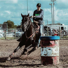 Rider wearing Thinline gear rounds barrel in equestrian competition.