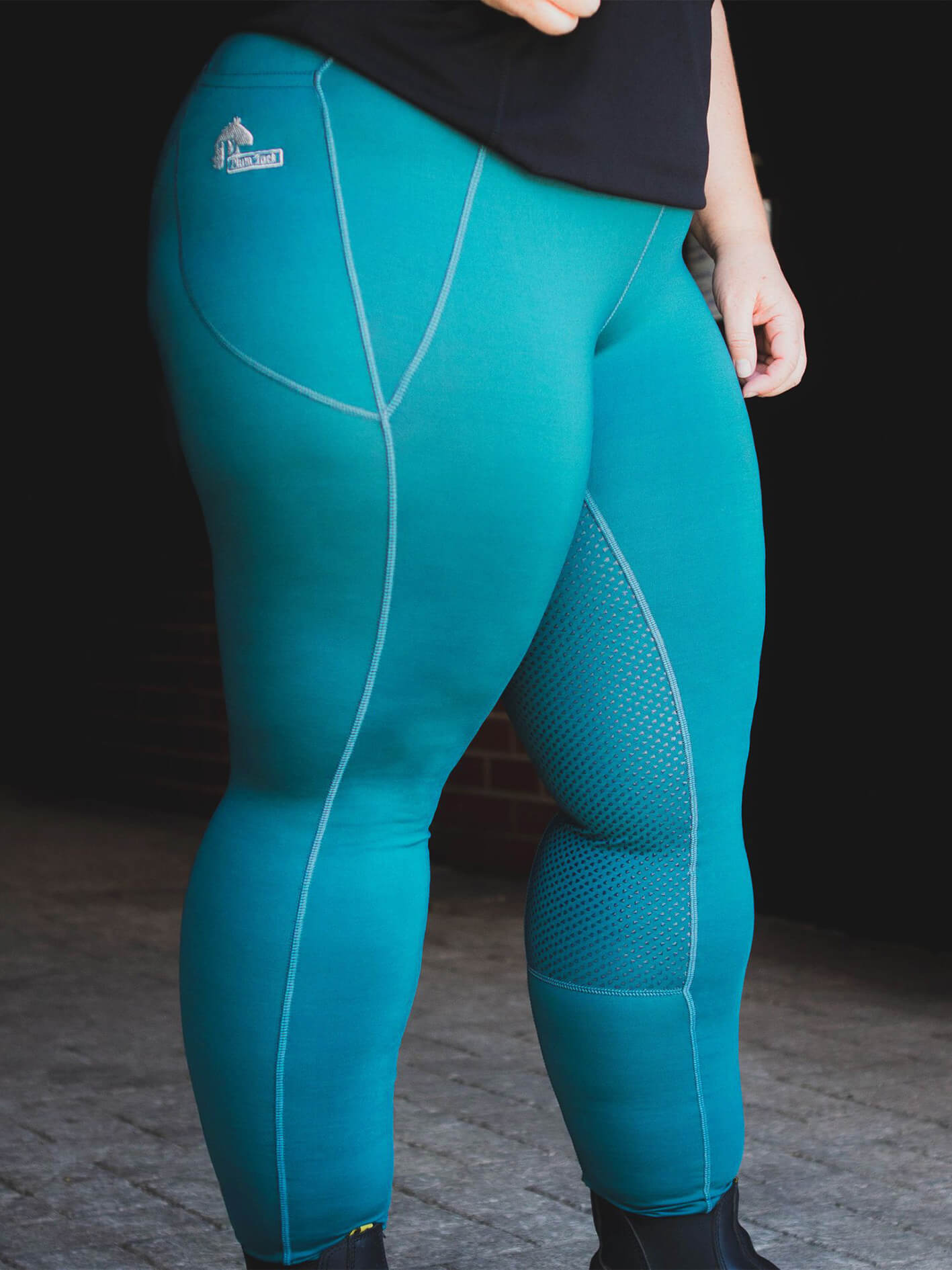 Person wearing blue horse riding tights with mesh panels.