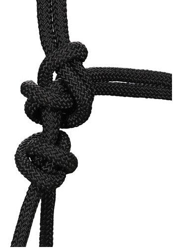 Close-up of black rope halter knots on a white background.