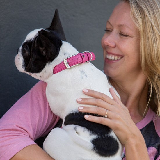 Woman smiling with dog wearing Rogz pink collar.