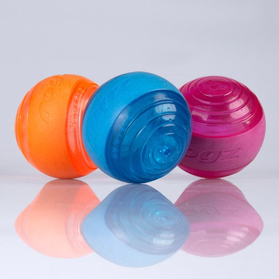 Three Rogz dog balls in orange, blue, and pink colors.