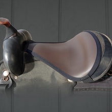 Thinline western saddle with black leather seat and padding.