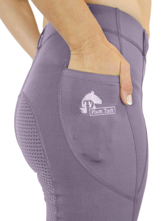 Close-up of purple horse riding tights with Plum Tick branding.