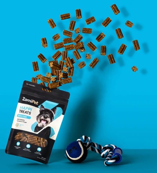 Zamipet Happi Treats dog snacks falling beside a toy on blue background.
