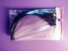 Thinline black zip ties in clear plastic bag, purple background.