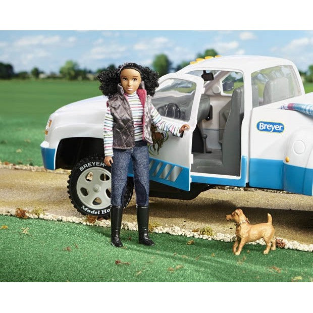Breyer Horse Toys doll with truck and dog on grassy backdrop.