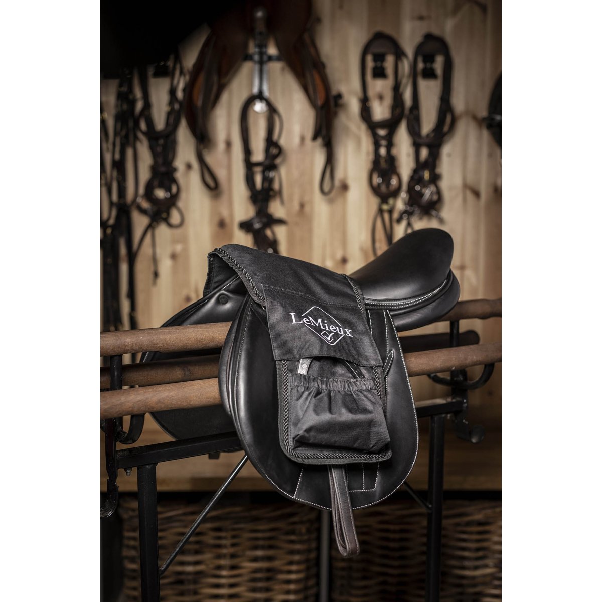 Black stirrup leathers on saddle, equestrian tack room background.